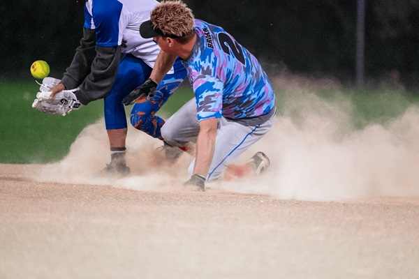 A softball play sliding into the base
