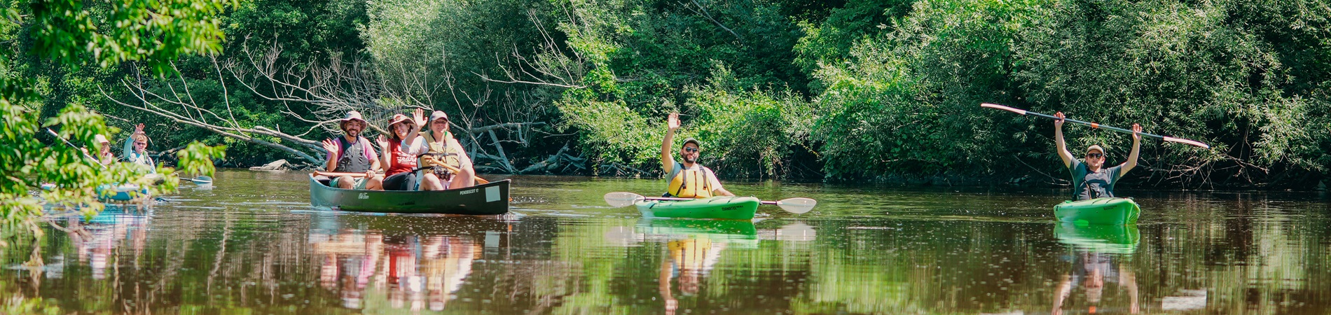 kayakers and canoers waving from the river trail