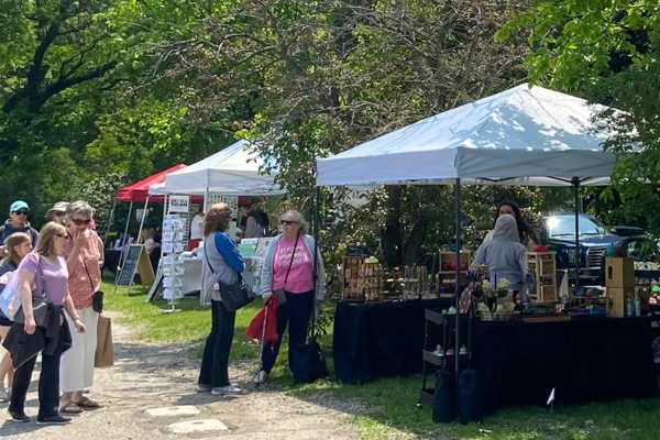 People looking at a booth at an outdoor market
