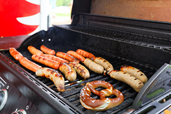 hotdogs, brats and pretzel on a grill