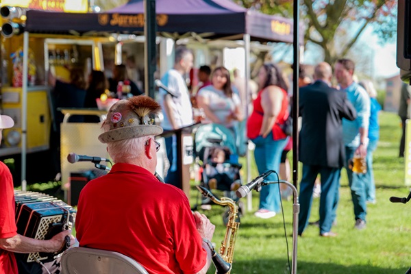 music playing to a crowd under a Sprecher tent