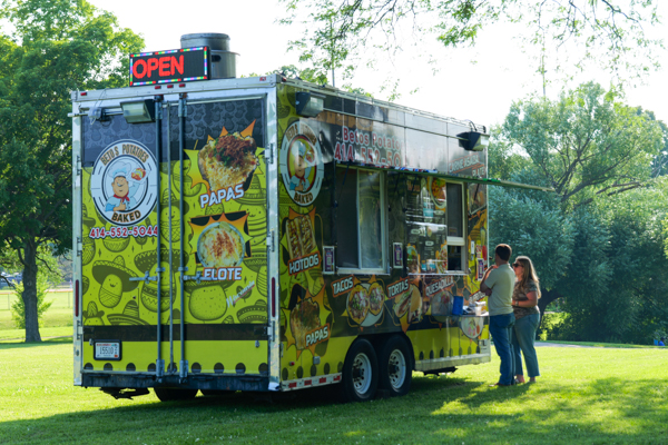 Two people looking at the menu for Betos Potatoes food truck