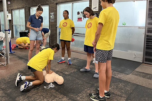 At the Junior Lifeguard summer program, participants gather to learn CPR