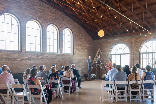 South Shore Pavilion: ceremony guests in chairs, wood-beamed ceiling with large windows